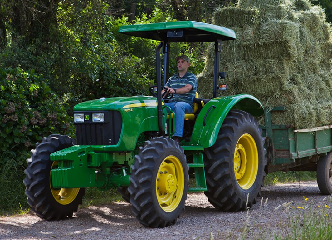 Tractor 5055E con la rastra de John Deere.