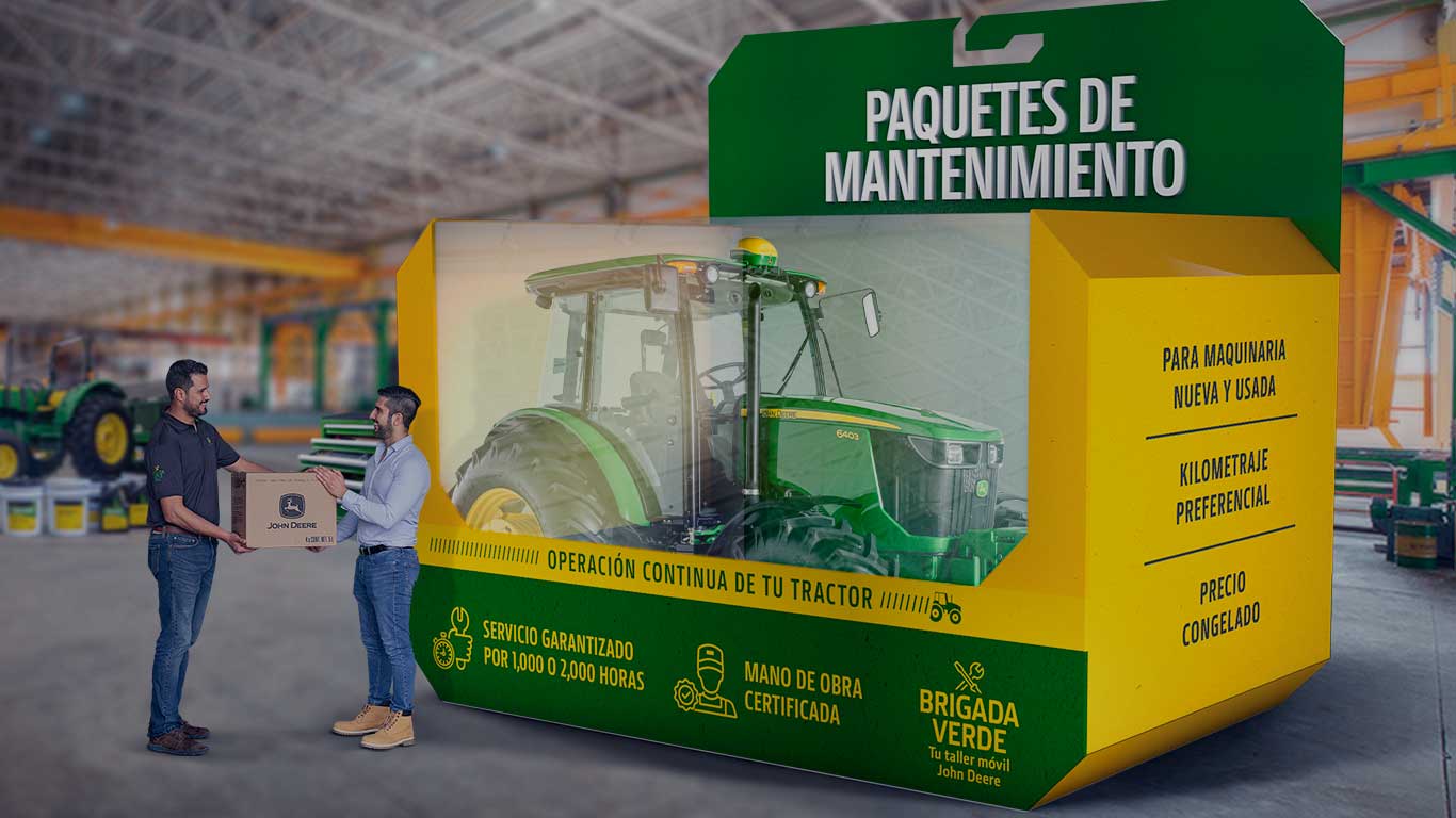 Tractor John Deere dentro de una caja de plástico, con dos personas a un lado.