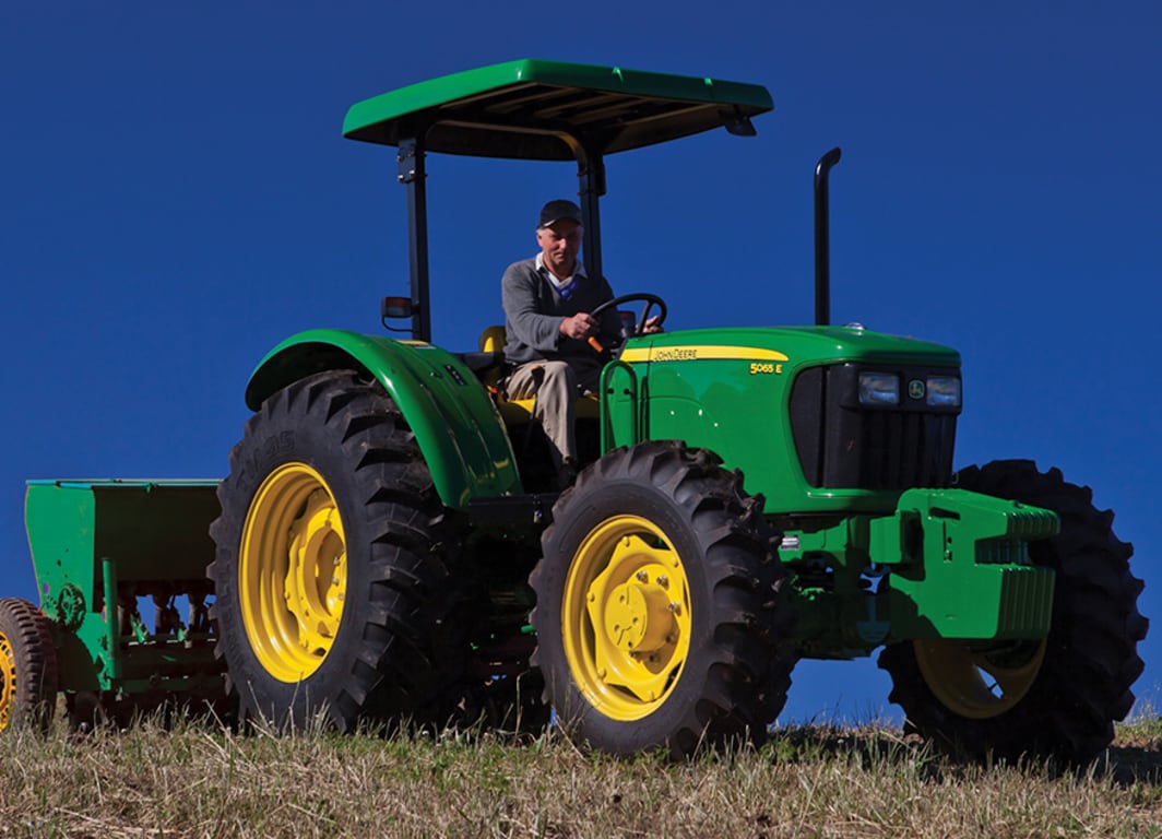 Tractor 5065E con la rastra de John Deere.