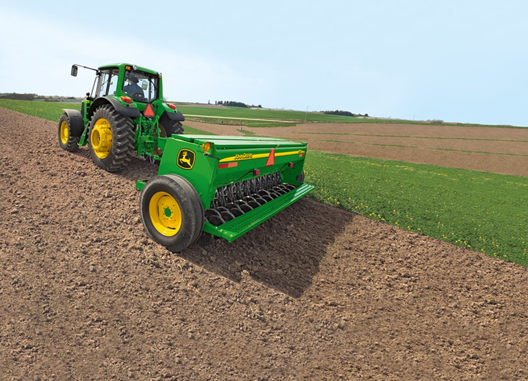 Sembradora BD11 en el campo con tractor John Deere.