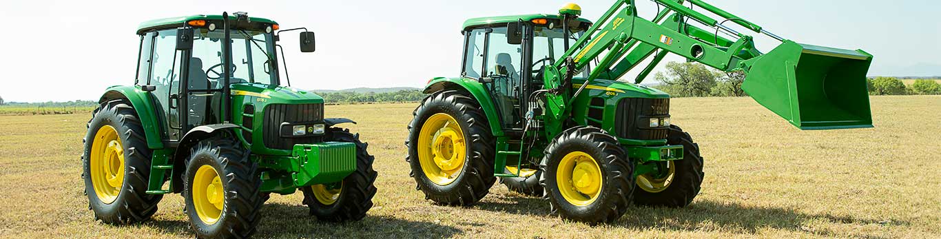 Dos tractores John Deere, uno al lado del otro, en el campo.